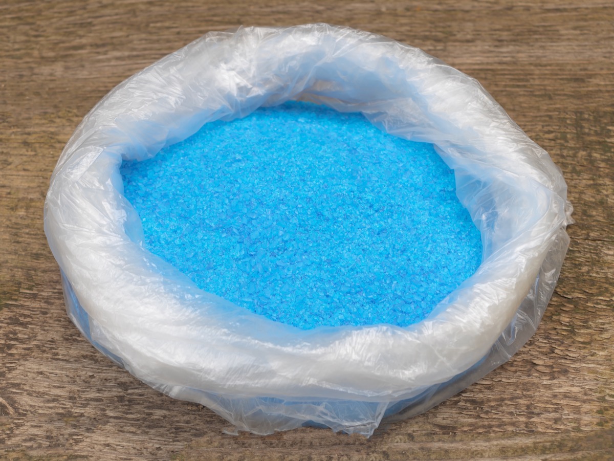 Copper Sulphate Crystals in a bag, Wooden background.