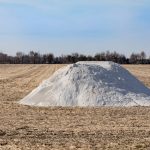 a pile of lime awaiting application on a farm field