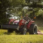 Promotional image of a man wearing a ball cap mowing using an Agco 2700E Series utility tractor.