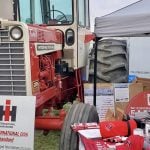 a classic red International Harvester tractor surrounded by brand memorabilia