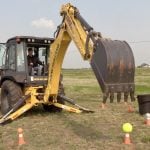Scott Garvey operating a backhoe at the Ag in Motion farm show