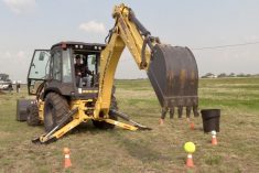 Scott Garvey operating a backhoe at the Ag in Motion farm show