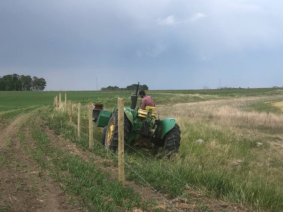 Gregory runs wire from the tractor for the new cross fence. Photo: Heather Eppich