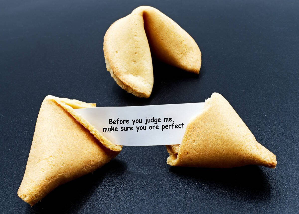 Before you judge me, make sure you are perfect. Cracked chinese fortune cookie with motivational message. Claudio Caridi/iStock/Getty Images