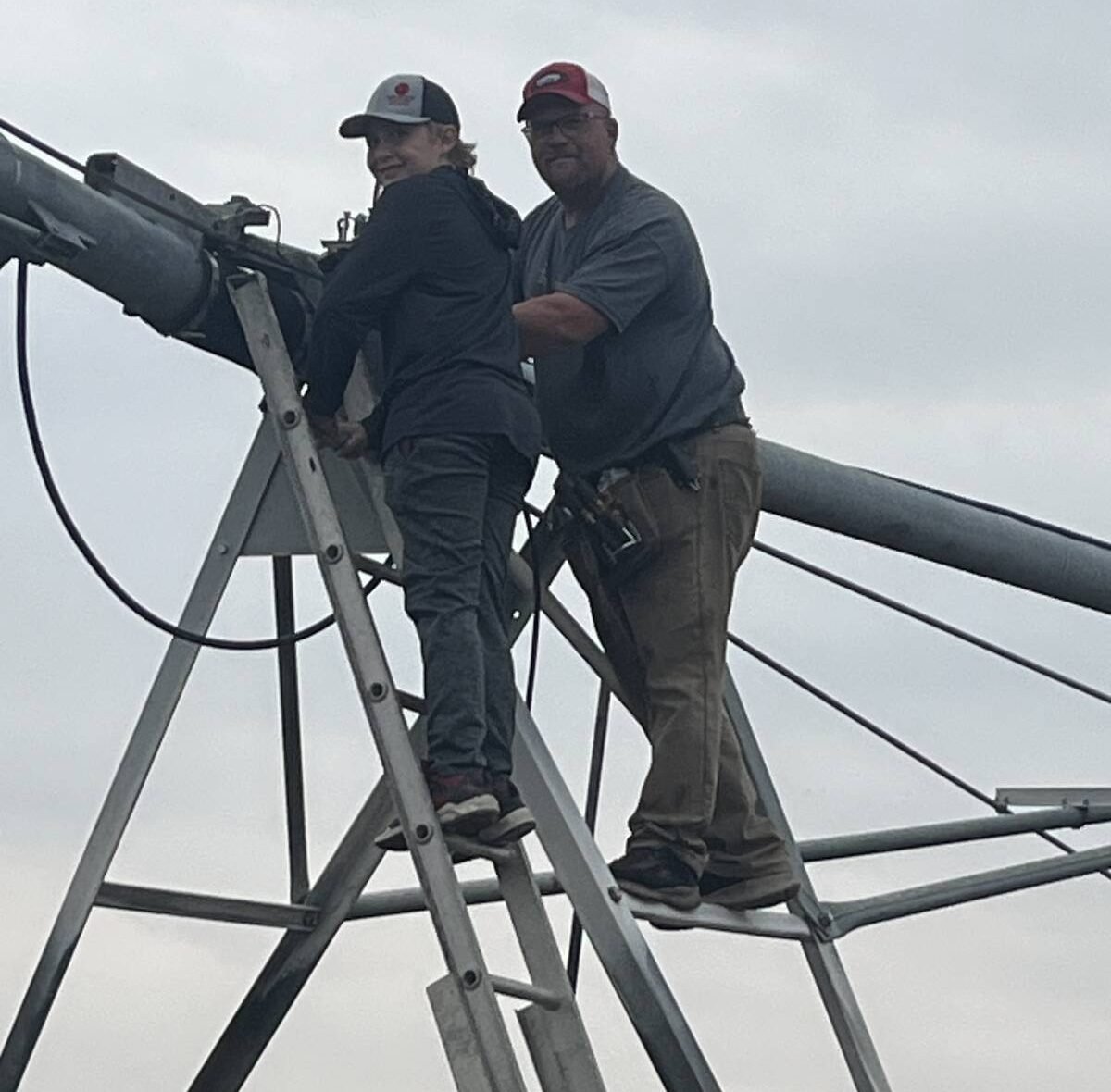 Aaron Gray and his son working on a newly installed irrigation pivot on the farm. PHOTO courtesy of Aaron Gray.