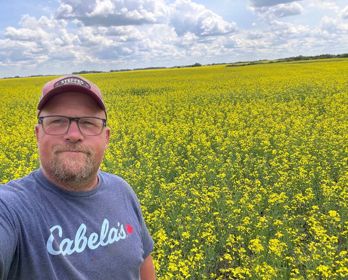 Aaron Gray by a canola field on his family's farm near Eyebrow, Sask. PHOTO courtesy of Aaron Gray.