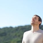 Man breathing fresh air near the mountains