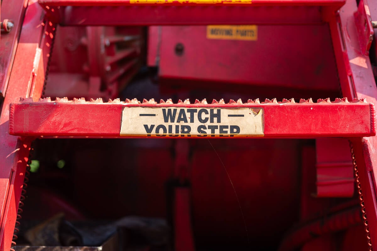 Close-up at metal steps part with anti-slip floor and caution sign of the working platform stairway. Industrial equipment object photo, selective focus.