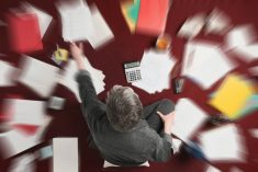 Accounting and processing a mess of stressful paperwork. Man doing challenging work with taxes, overhead shot with zoom blur effect
