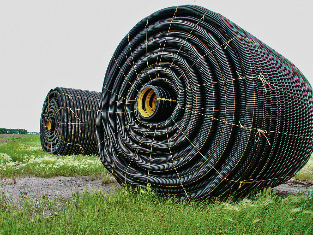 Rolls of 
tile drainage piping sit a field, waiting for installation. Photo: File