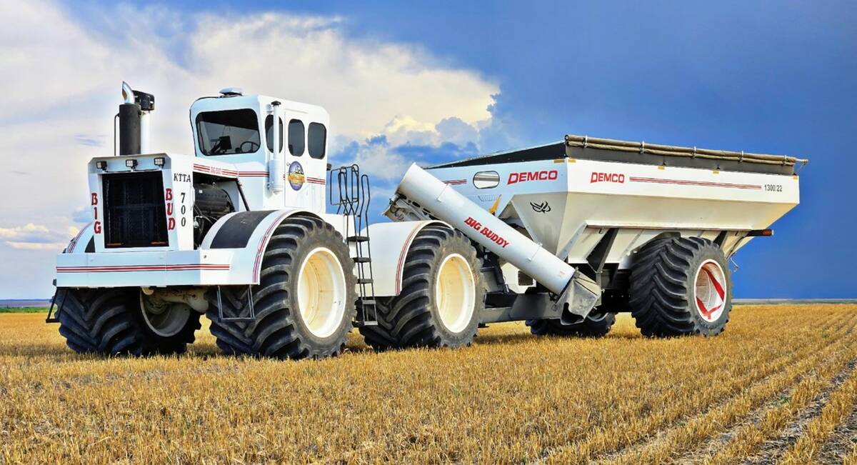 an oversized white tractor towing an equally large-scale white grain cart