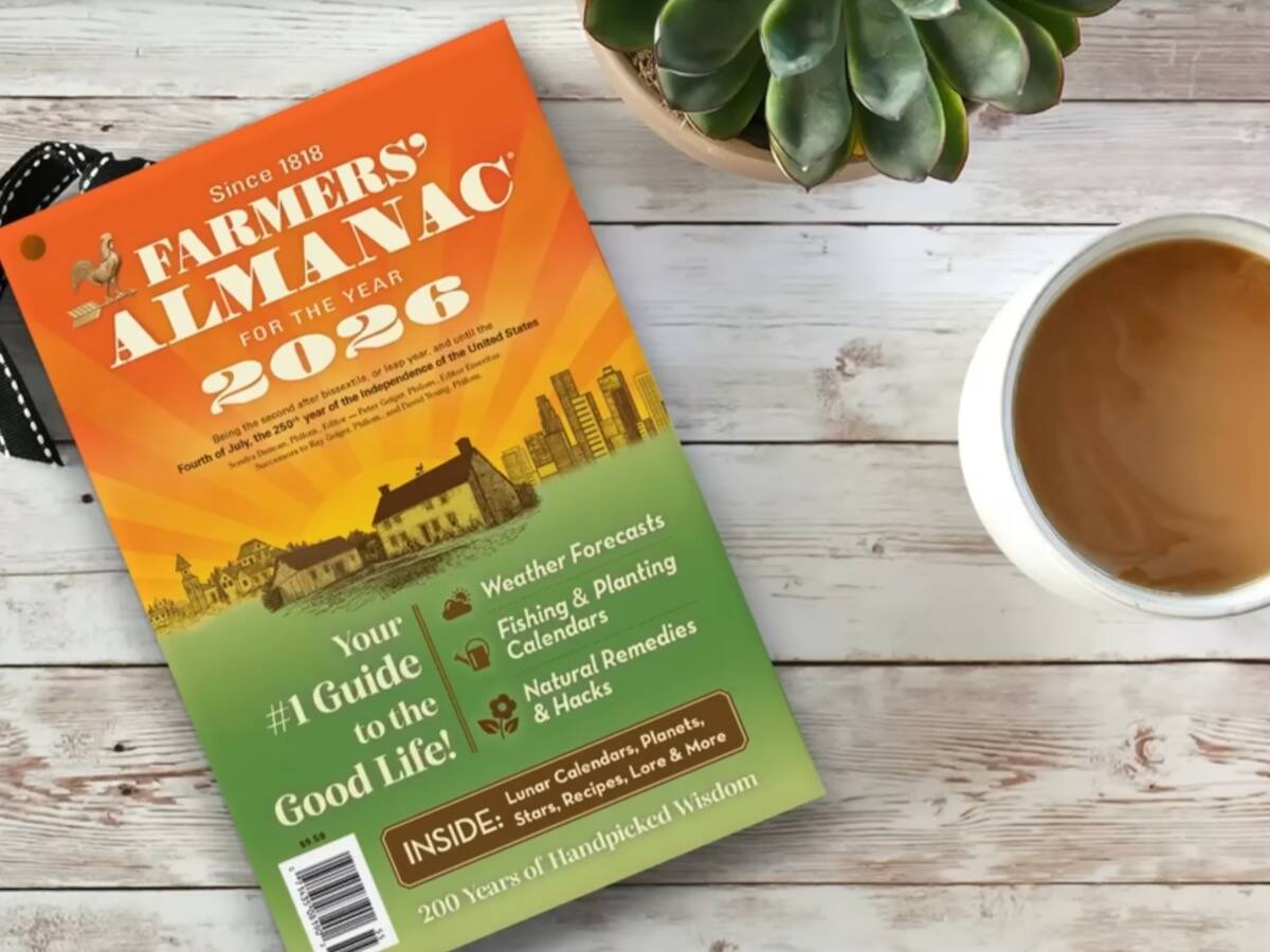 Copy of the 2026 Farmers' Almanac on a table with a cup of coffee