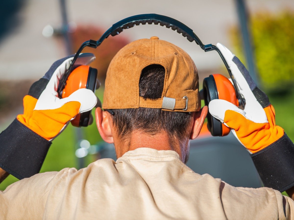 a worker puts on hearing protection on a rural work site