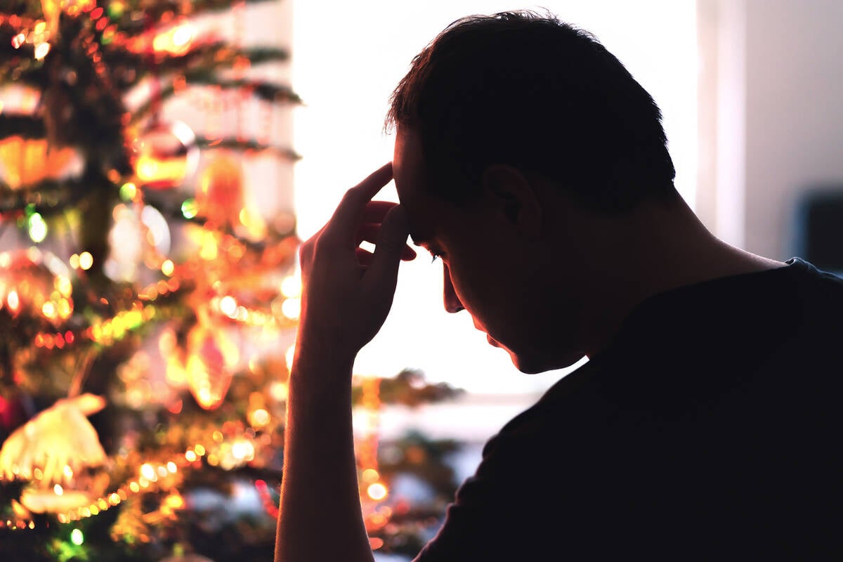 Sad on Christmas. Unhappy, lonely or tired man with stress, grief or depression. Family fight, loneliness, frustration or money problem on Xmas. Sick person with flu, pain and headache on holiday. Tero Vesalainen/iStock/Getty Images