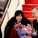 Canada’s Prime Minister Mark Carney receives flowers from Lu You Ci, 11, upon his arrival at Beijing Capital International Airport, during the first visit by a Canadian Prime Minister to China since 2017, in Beijing, China January 14, 2026.  Photo: REUTERS/Carlos Osorio
