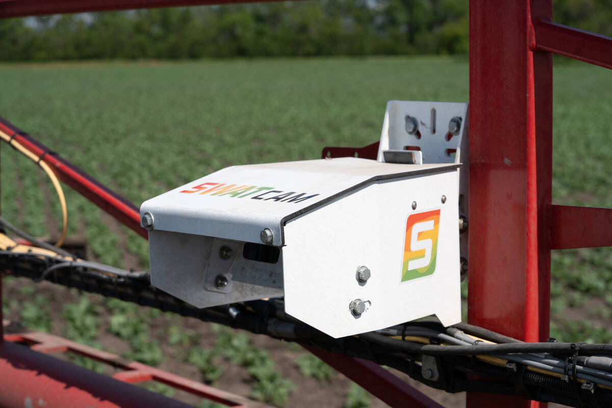A close-up of a SWAT Cam unit mounted on a sprayer boom. The system uses machine learning to analyze images and generate crop and weed maps.