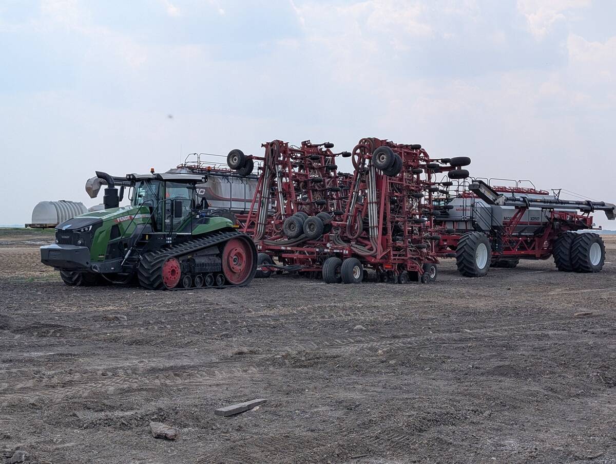 Ground level side view of one hundred-foot Morris Quantum air seeder with Morris 10 Series 1440 bushel air cart, folded for transport.