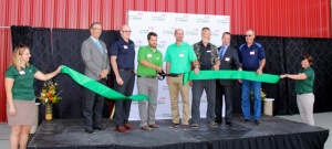 Travis Coleman, centre cuts the ribbon to officially open the new DuPont Pioneer corn research facility near Lethbridge as company and local and provincial government officials look on.