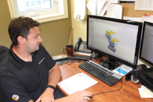 Engineer Daniel Michaluk shows the computer model the new seeding system evolved from