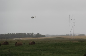 Braving winds, this pilot hovered within feet of the uprights hanging high-tension cables